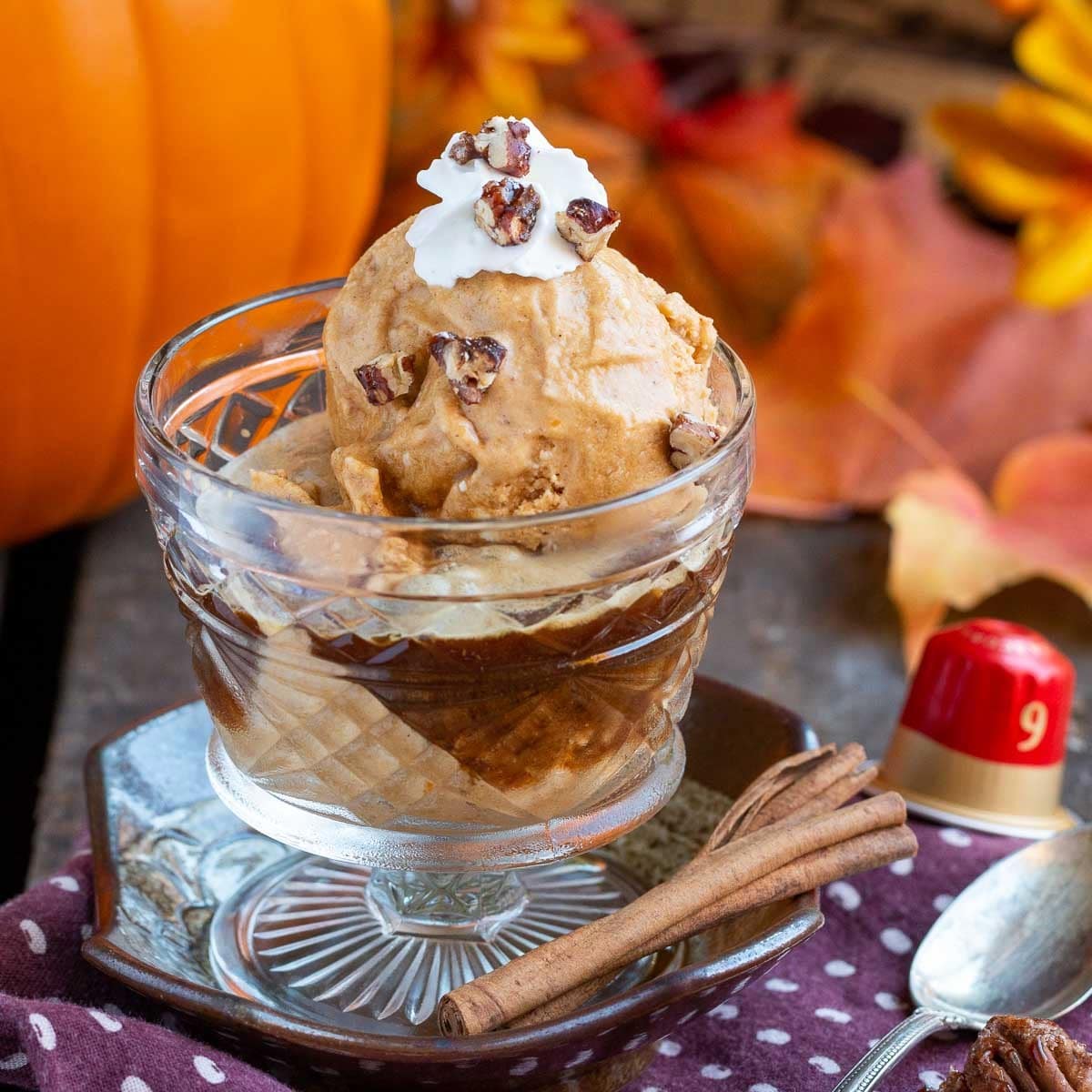 Dairy free pumpkin ice cream affogato in a glass vintage cup topped with coconut topping and crushed pecans.
