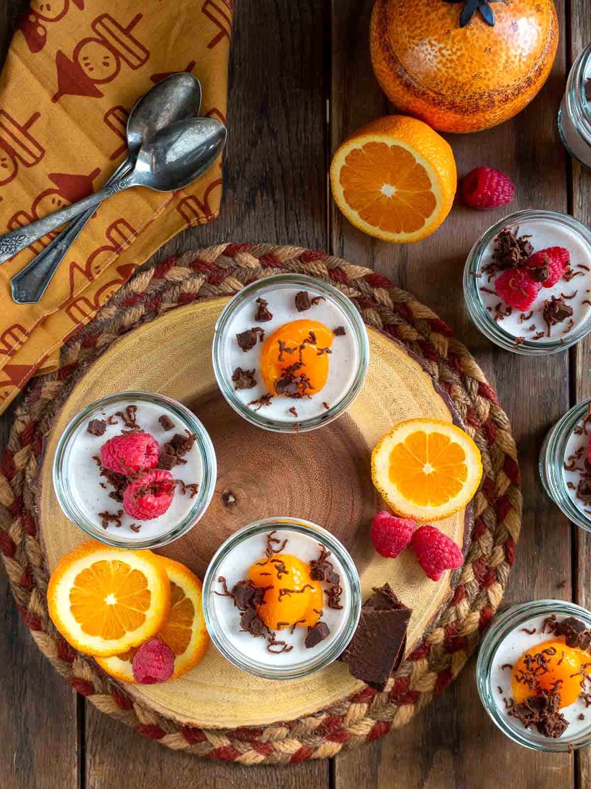 Chai spiced coconut jelly on a wooden board garnished with mandarin oranges, raspberries and dark chocolate.