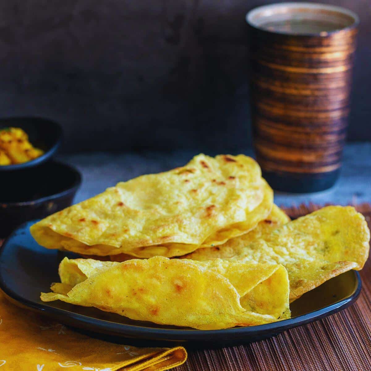 Cooked instant rice flour dosa on a Black plate rolled.