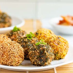 Kimchi Korean rice balls on a white plate coated in homemade furikake rice seasoning.