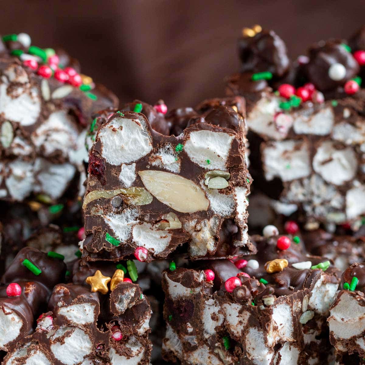 Chocolate rice cake rocky road bars slices sticked on a plate showing the crispy rice cakes, marshmallows and all the add ins.