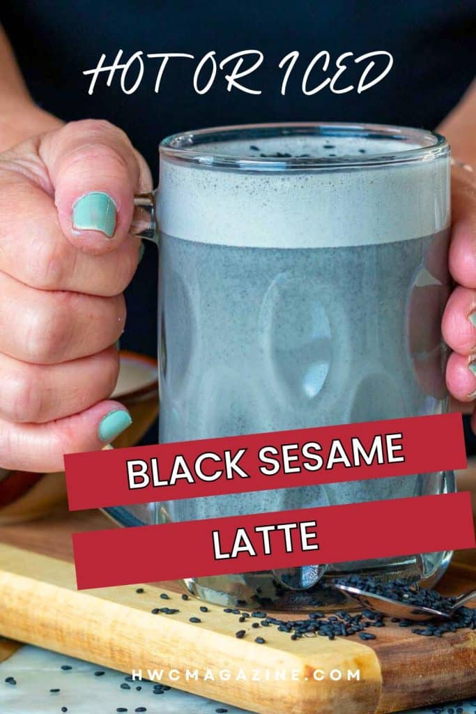 Hot black sesame latte held in a glass mug.