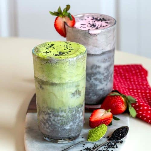 2 iced black sesame latte - one topped with matcha cold foam and the other topped with strawberry cold foam.
