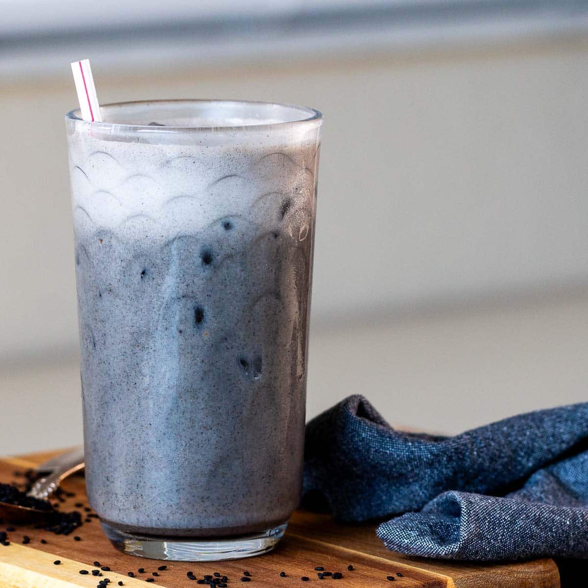 Cold iced black sesame latte frothy and creamy in a clear glass. 