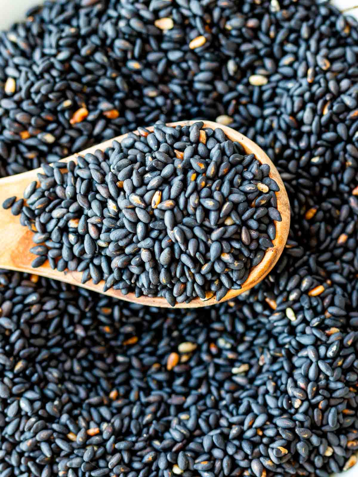 Toasting whole black sesame seeds in a pan.