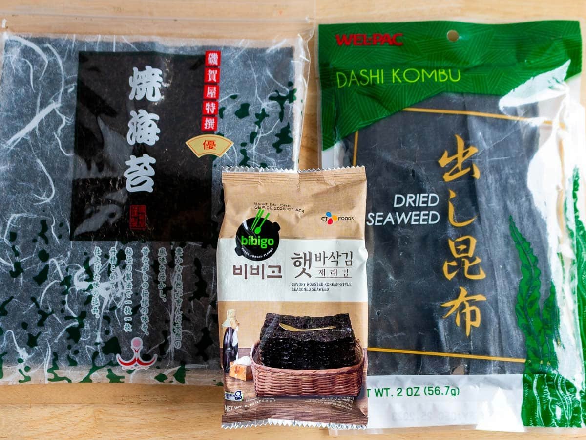 Dried seaweed sheets (Nori), seaweed snacks and kombu laid on the wooden table. 