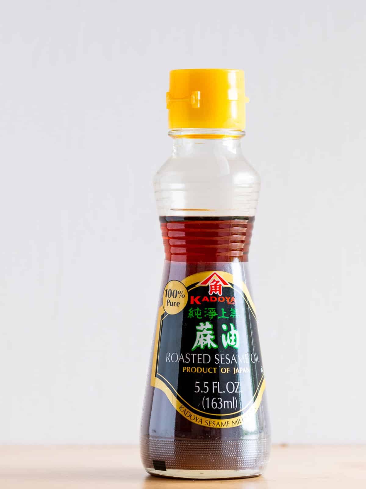 Roasted sesame oil Japanese brand sitting on the wooden table. 