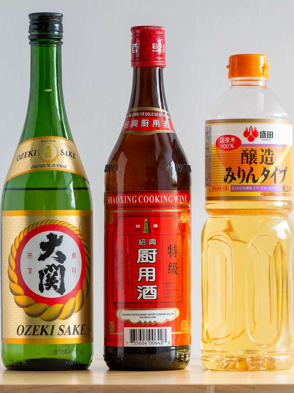 Chinese Shaoxing, Japanese mirin and sake cooking wines on the wooden table. 