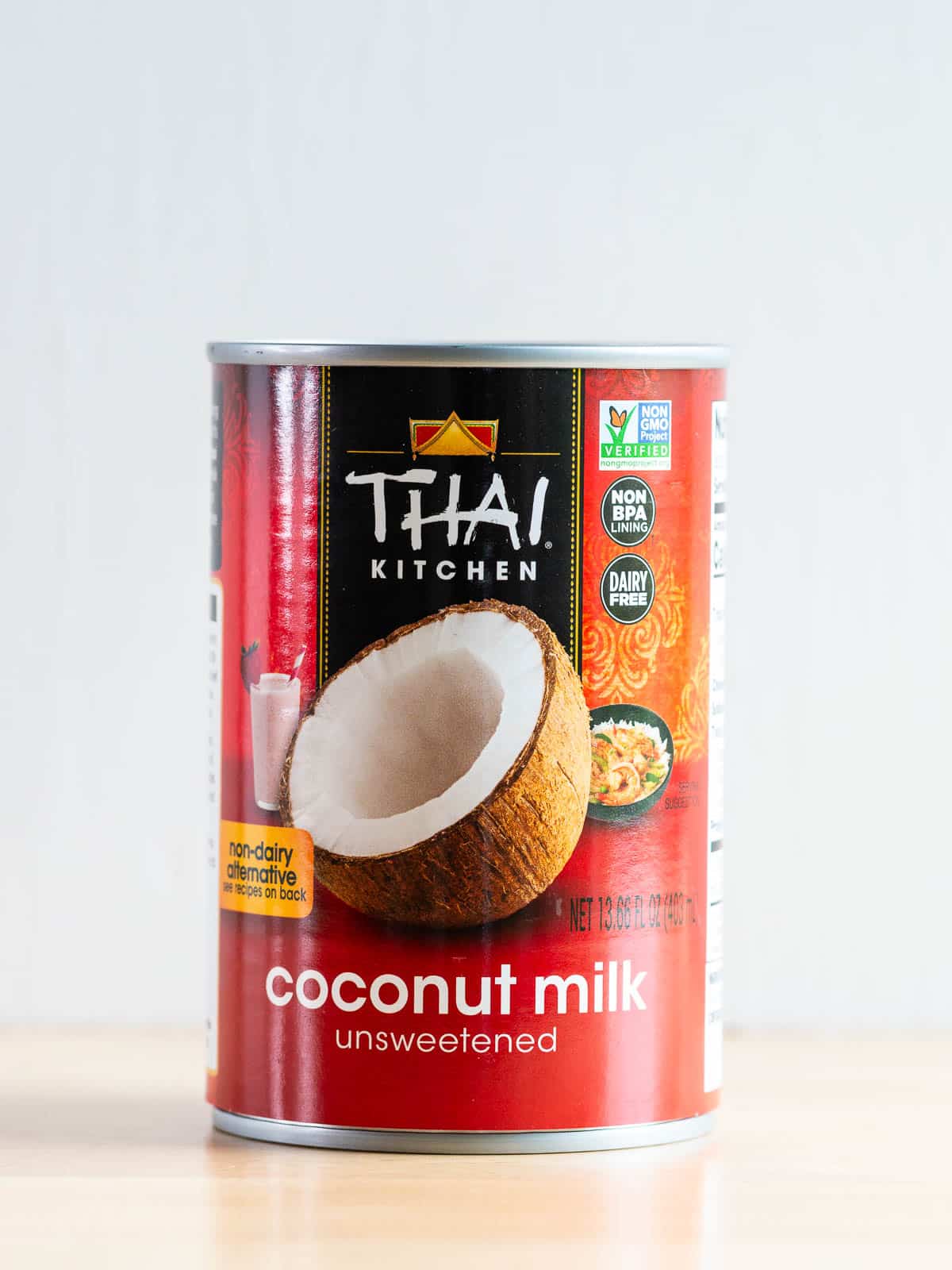A can of unsweetened Thai Kitchen coconut milk on the wooden table.