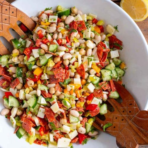 Antipasto Style Italian bean salad getting tossed to mix with the lemon white balsamic vinaigrette.