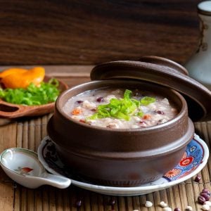 A steaming bowl of Instant pot chicken congee with job's tears, red beans and rice.