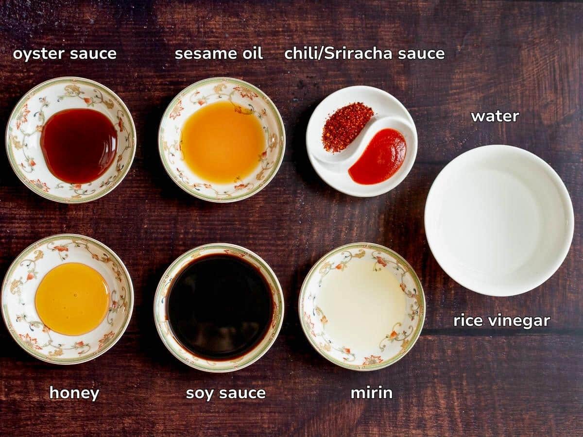 Sauce ingredients in tiny bowls on a brown table. 