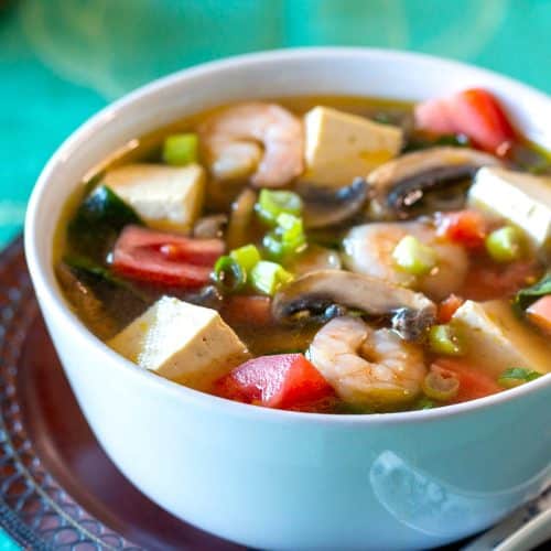 Steamy white bowl of Asian shrimp and tofu soup.