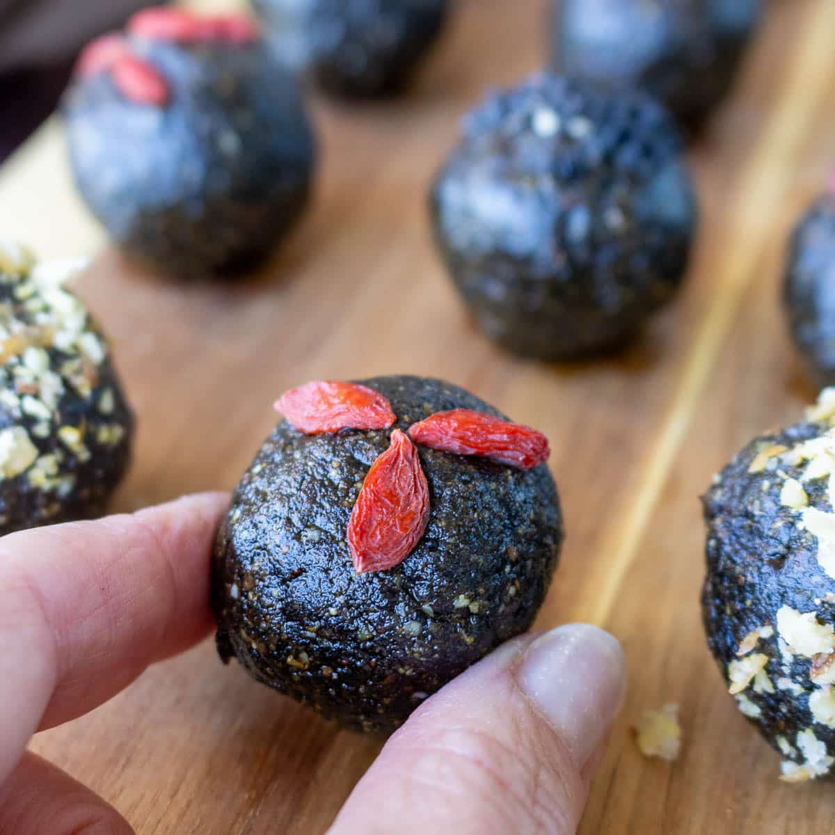 Grabbing a decorated black sesame ball from the serving tray.