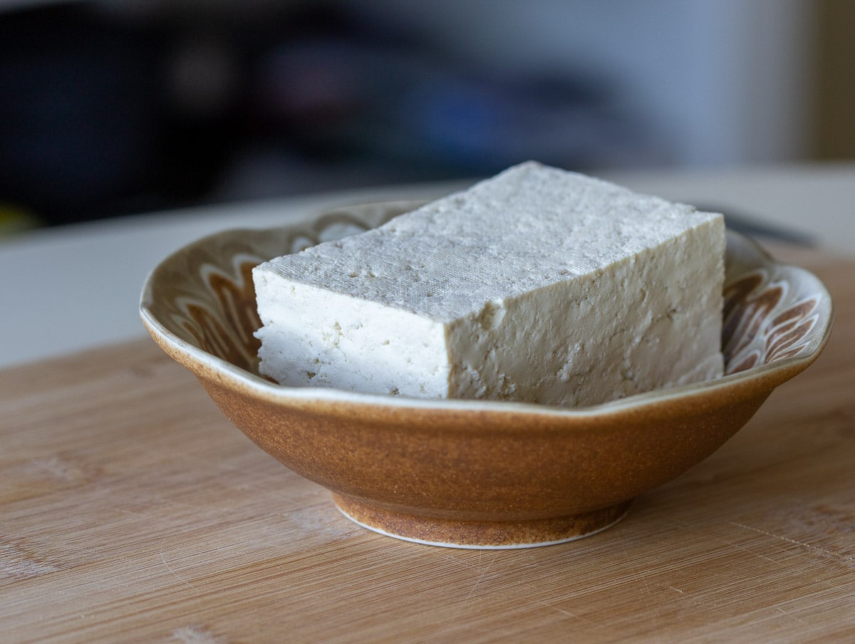 extra firm tofu in a brown bowl