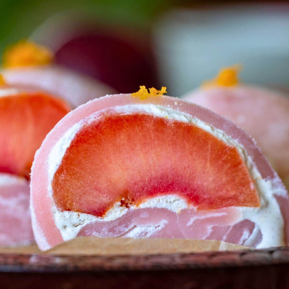 plum daifuku cut in half showing the purple hue of the naturally dyed mochi skin.