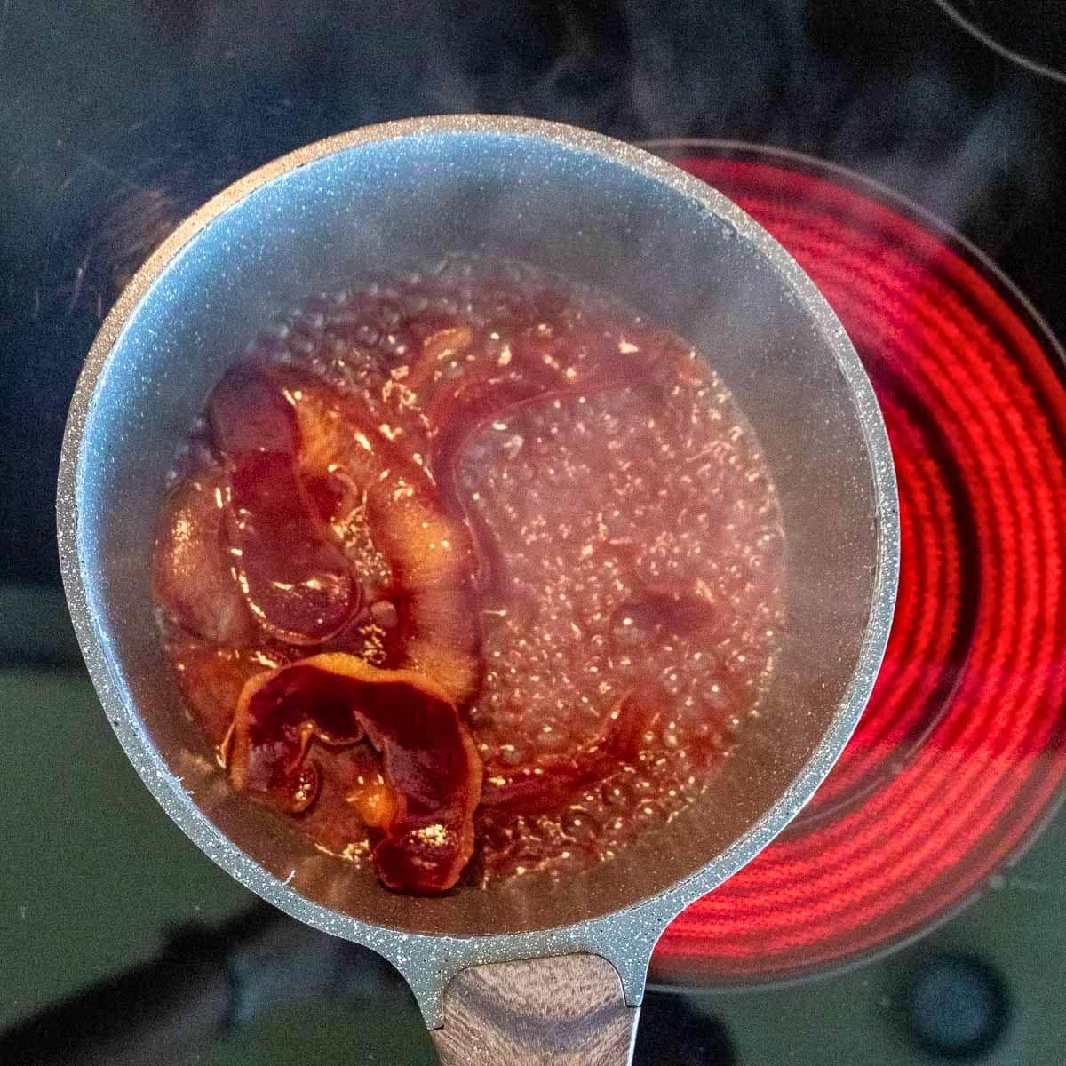 Cooking fresh plum peels in water over the stovetop to make a natural purple plum dye.